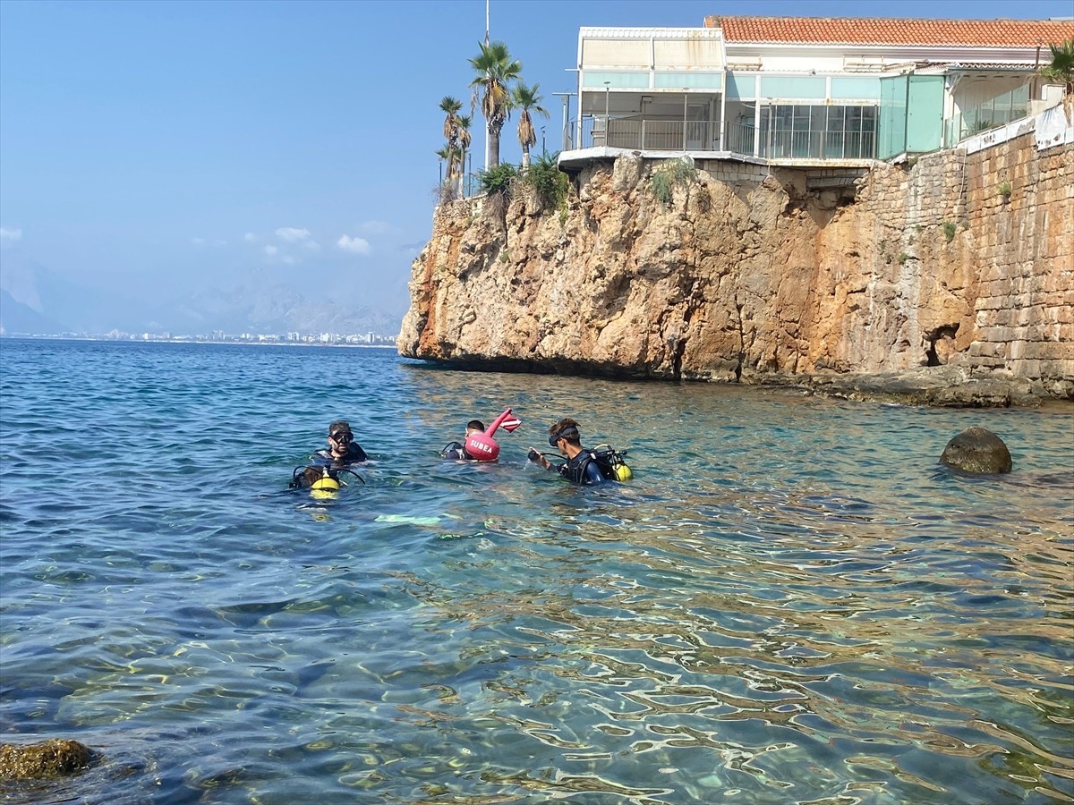 Antalya'nın tarihi Kaleiçi bölgesi falezler alanından dalış yapan ziyaretçiler, kentin su altı...