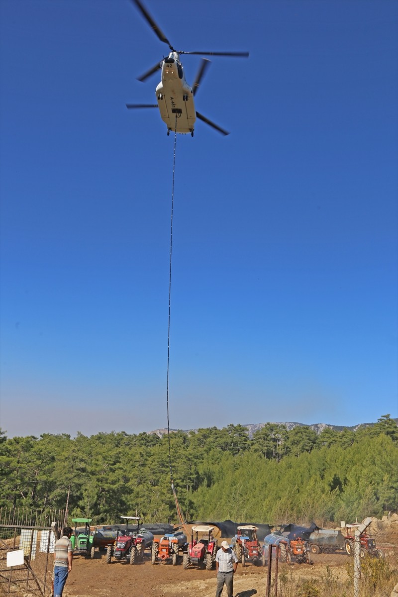 Muğla'nın Menteşe ilçelerindeki orman yangınına havadan ve karadan müdahale sürerken köylüler...