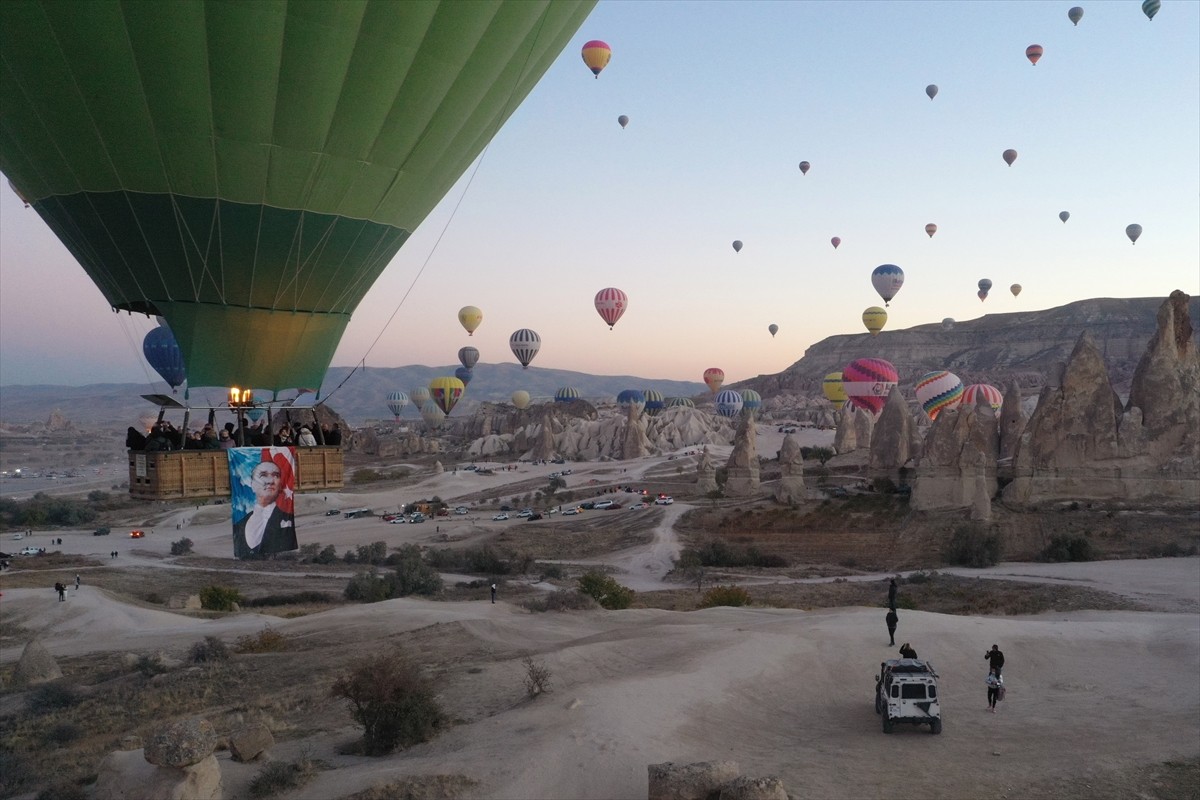 Kapadokya'da, peribacaları üzerinde süzülen sıcak hava balonları Türk bayrakları ve Atatürk...