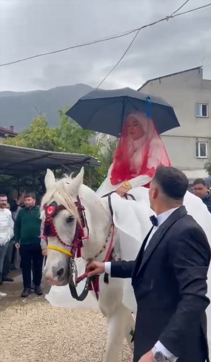 Antalya'nın Finike ilçesinde düğününde ata binen gelinin yağış altında şemsiyeyle tur atması...