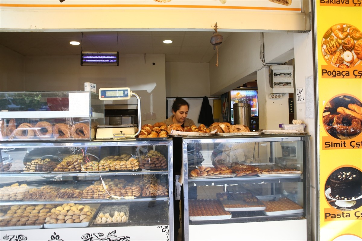 Hatay'ın İskenderun ilçesinde üşümesin diye simit fırınına alınan kadının, iş yerindeki masa...